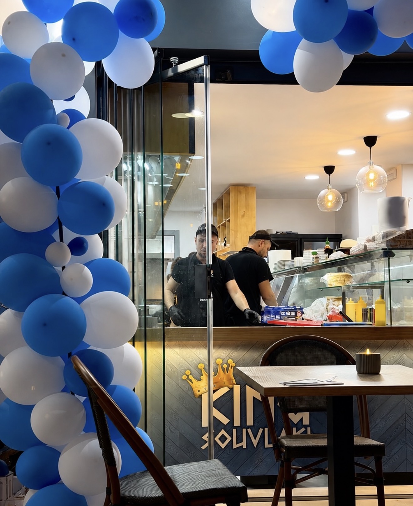Inside King Souvlaki restaurant with the golden crown logo and open kitchen